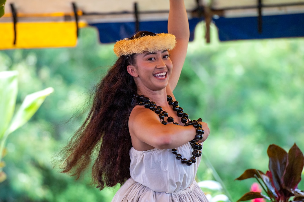 Hula dancer in white smiles while dancing