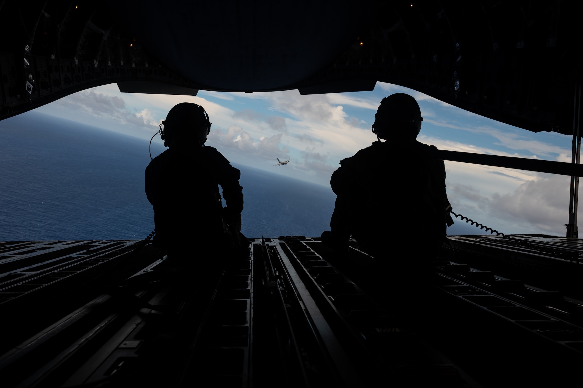 Royal Australian Air Force Corporal Charlotte Roe, a  C-17 Globemaster III Loadmaster assigned to No. 36 Squadron RAAF in Base Amberley, Australia, left, and U.S. Air Force Master Sgt Jason Livingston, a C-17 Loadmaster assigned to 16 Airlift Squadron in Joint Base Charleston, SC, right, watch as a U.S. C-17 from the 62nd Airlift Wing in Joint Base Lewis-McChord, Washington, flies behind a RAAF C-17 from No. 36 SQN over the Commonwealth of the Northern Mariana Islands during exercise Mobility Guardian 23, July 12, 2023. MG23 is an opportunity to train alongside our Allies and partners to demonstrate interoperability and bolster our collective ability to support a free and open Indo-Pacific. (U.S. Air Force photo by Tech. Sgt. Sean Carnes)