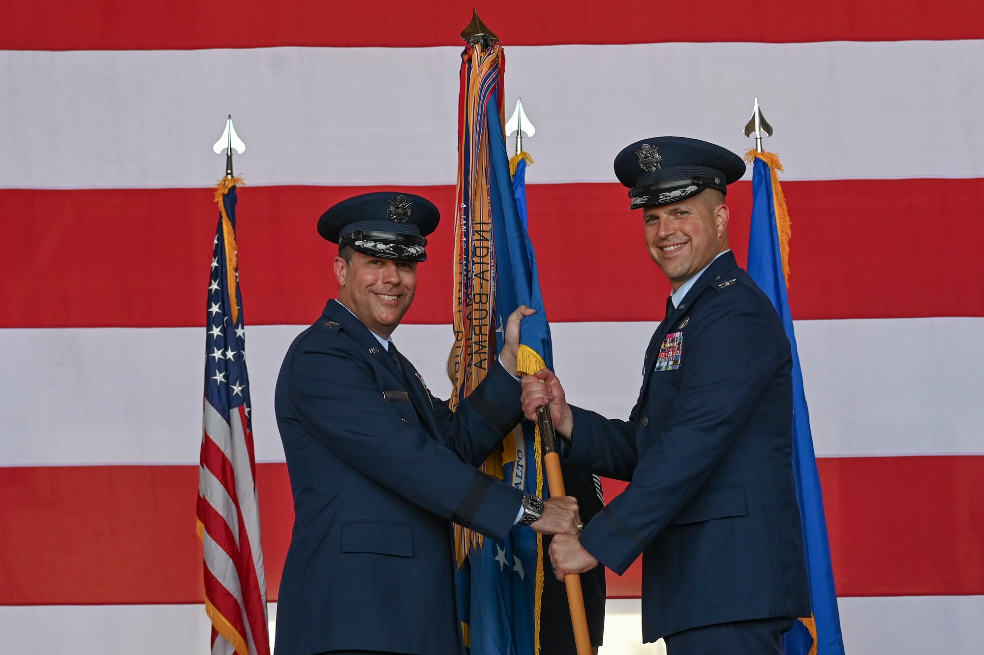 U.S. Air Force Maj. Gen. Andrew Gebara, left, 8th Air Force and Joint-Global Strike Operations Center commander, presents the guidon to Col. Seth Spanier, incoming 7th Bomb Wing commander, during the 7th BW change of command ceremony inside the Three Bay Hangar at Dyess Air Force Base, Texas, July 24, 2023. The ceremony symbolizes the transfer of authority between one commander to another. Spanier took command of the 7th BW from Col. Joseph Kramer. (U.S. Air Force photo by Airman 1st Class Emma Anderson)