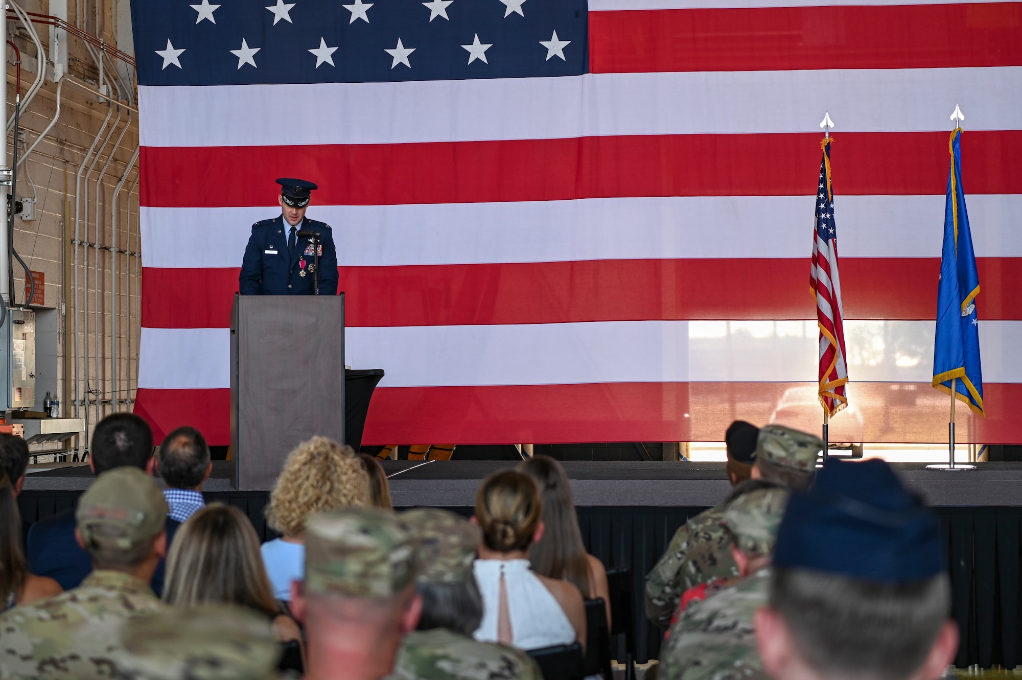 U.S. Air Force Col. Joseph Kramer, outgoing 7th Bomb Wing commander, delivers remarks during the 7th BW change of command ceremony inside the Three Bay Hangar at Dyess Air Force Base, Texas, July 24, 2023. The ceremony symbolizes the transfer of authority between one commander to another. Spanier took command of the 7th BW from Col. Joseph Kramer. (U.S. Air Force photo by Airman 1st Class Emma Anderson)