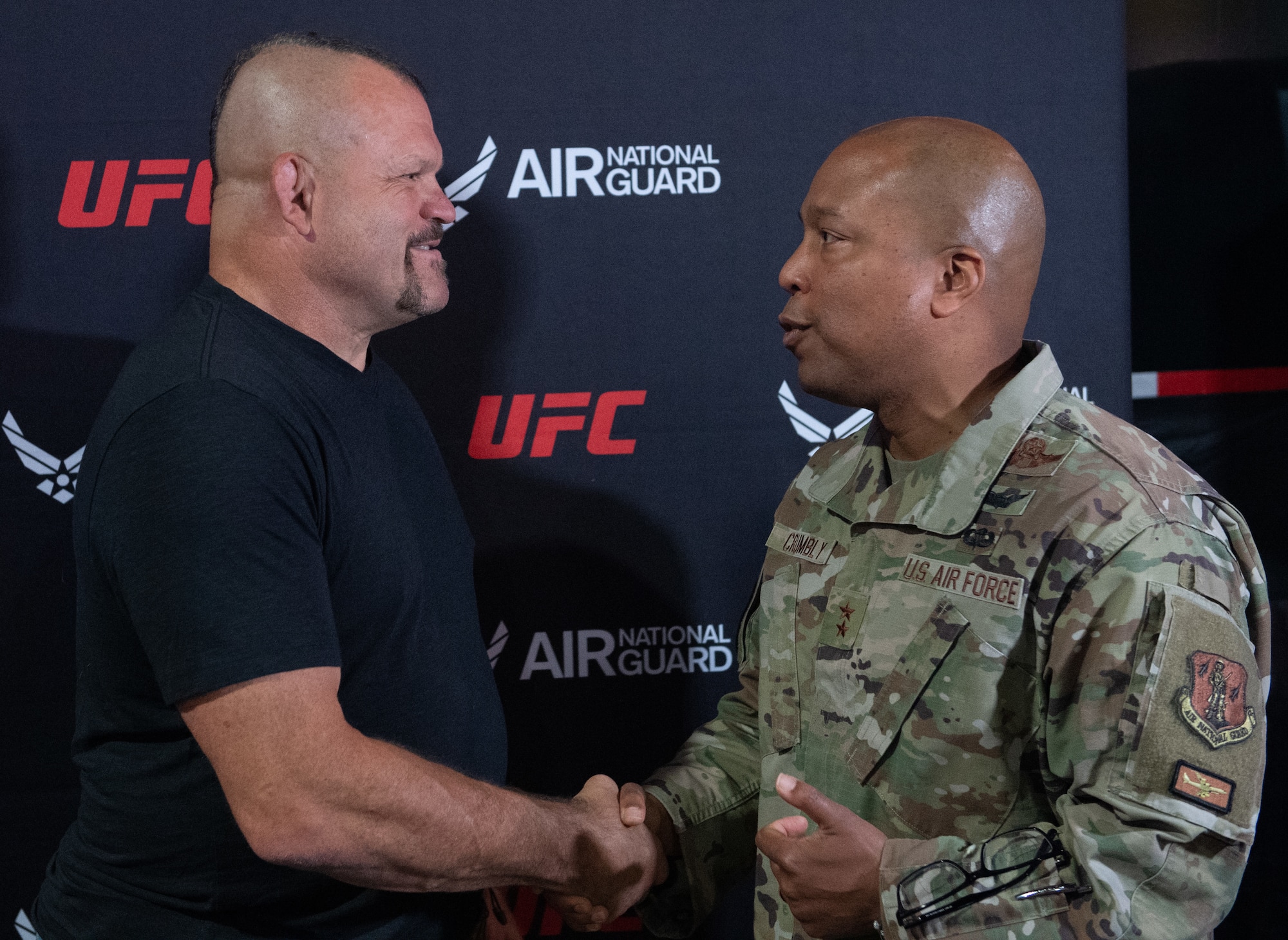 Maj. Gen. Konata Crumbly, Air National Guard advisor to the Air Force Recruiting Service commander, presents Chuck "The Iceman" Liddell, retired American mixed martial artist, a coin at the Ultimate Fighting Championship International Fight Week event in Las Vegas, July 3-9, 2023.