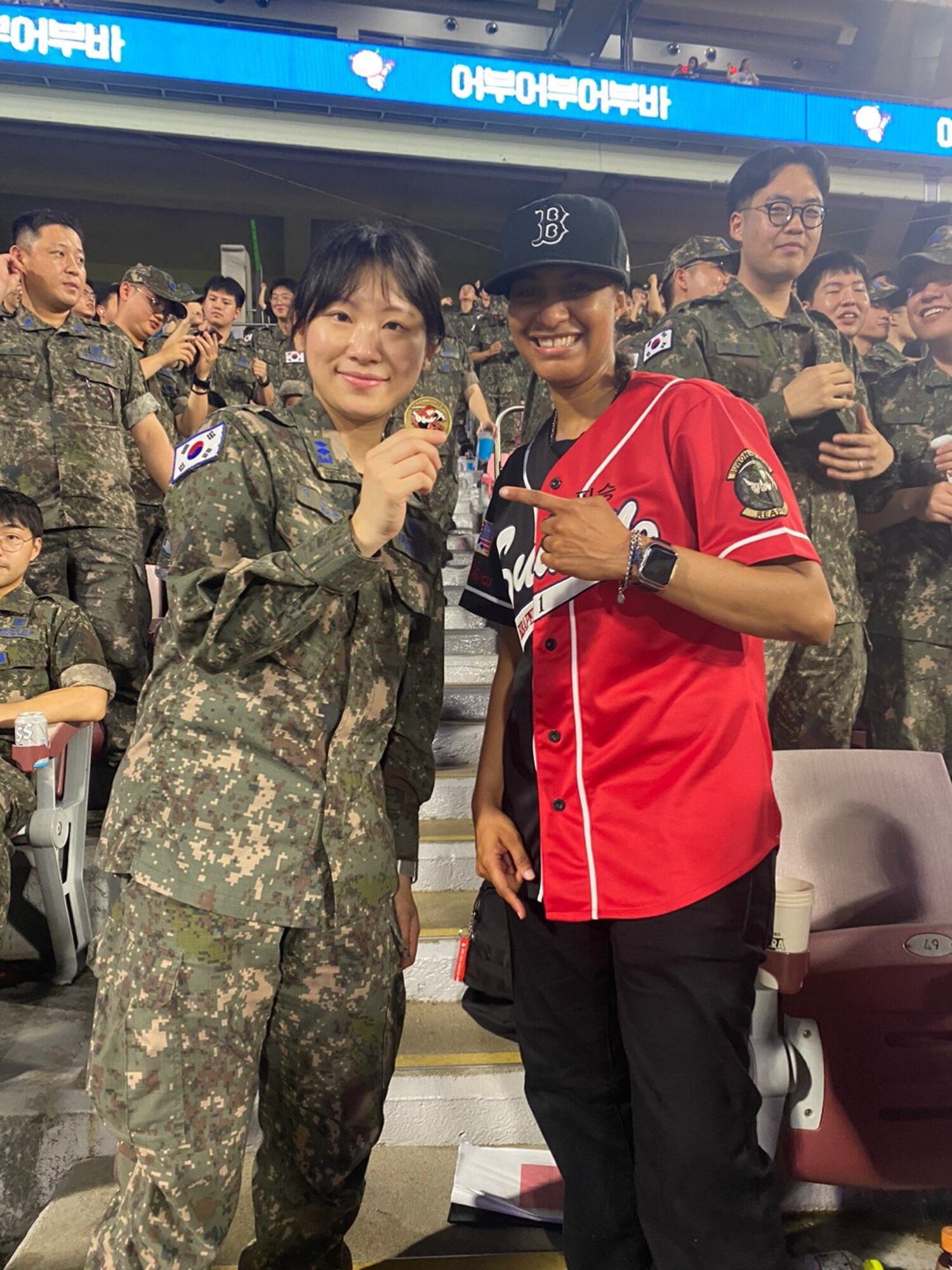 U.S. Air Force Maj. Joyce Lewis, right, 607th Materiel Maintenance Squadron Detachment 2 commander, coins a Republic of Korea Air Force member  Gyeonggi-do, ROK, June 30, 2023. The baseball game celebrated the 70th anniversary of the U.S.-ROK alliance. (U.S. Air Force courtesy photo by Maj. Joyce Lewis)
