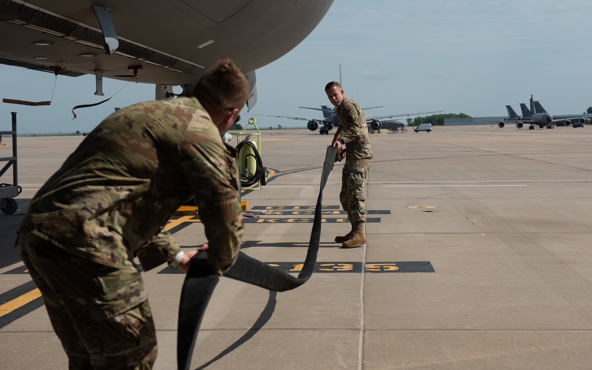 Tech. Sgt. Cody Post, 22nd Logistic Readiness Squadron noncommissioned officer in charge of fuels distribution, right, and Master Sgt. Justin Engel, 22nd LRS fuels operation section chief, untwist a fuel hose next to a KC-46A Pegasus July 13, 2023, at McConnell Air Force Base, Kansas. Post, Engel and other 22nd LRS Airmen hooked the truck up to a Versatile Integrating Partner Equipment Refueling (VIPER) kit, which can be used to fuel any aircraft in the world. (U.S. Air Force photo by Staff Sgt. Tryphena Mayhugh)