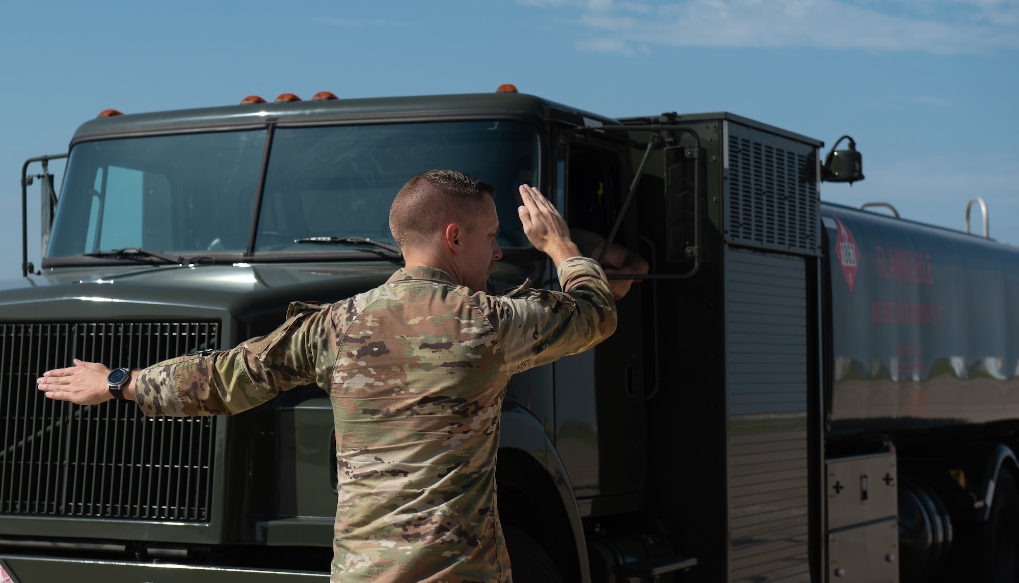 Tech. Sgt. Cody Post, 22nd Logistic Readiness Squadron noncommissioned officer in charge of fuels distribution, marshals a fuels truck into place July 13, 2023, at McConnell Air Force Base, Kansas. Post and other 22nd LRS Airmen hooked the truck up to a Versatile Integrating Partner Equipment Refueling (VIPER) kit, which can be used to fuel any aircraft in the world. (U.S. Air Force photo by Staff Sgt. Tryphena Mayhugh)