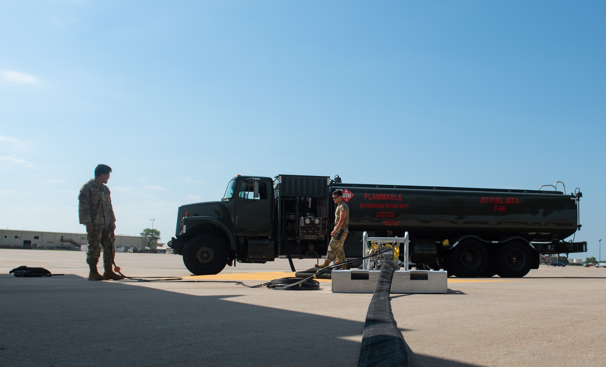 Airman 1st Class Ivan Herrera, 22nd Logistic Readiness Squadron fuels service center controller, left, and Airman 1st Class Alan Mitchell, 22nd LRS fuels distribution operator, oversee a Versatile Integrating Partner Equipment Refueling (VIPER) kit connected to a fuels truck July 13, 2023, at McConnell Air Force Base, Kansas. VIPER kits have the ability to conduct hot pit refueling of aircraft with any fuel infrastructure, making them a part of the Agile Combat Employment (ACE) construct. (U.S. Air Force photo by Staff Sgt. Tryphena Mayhugh)
