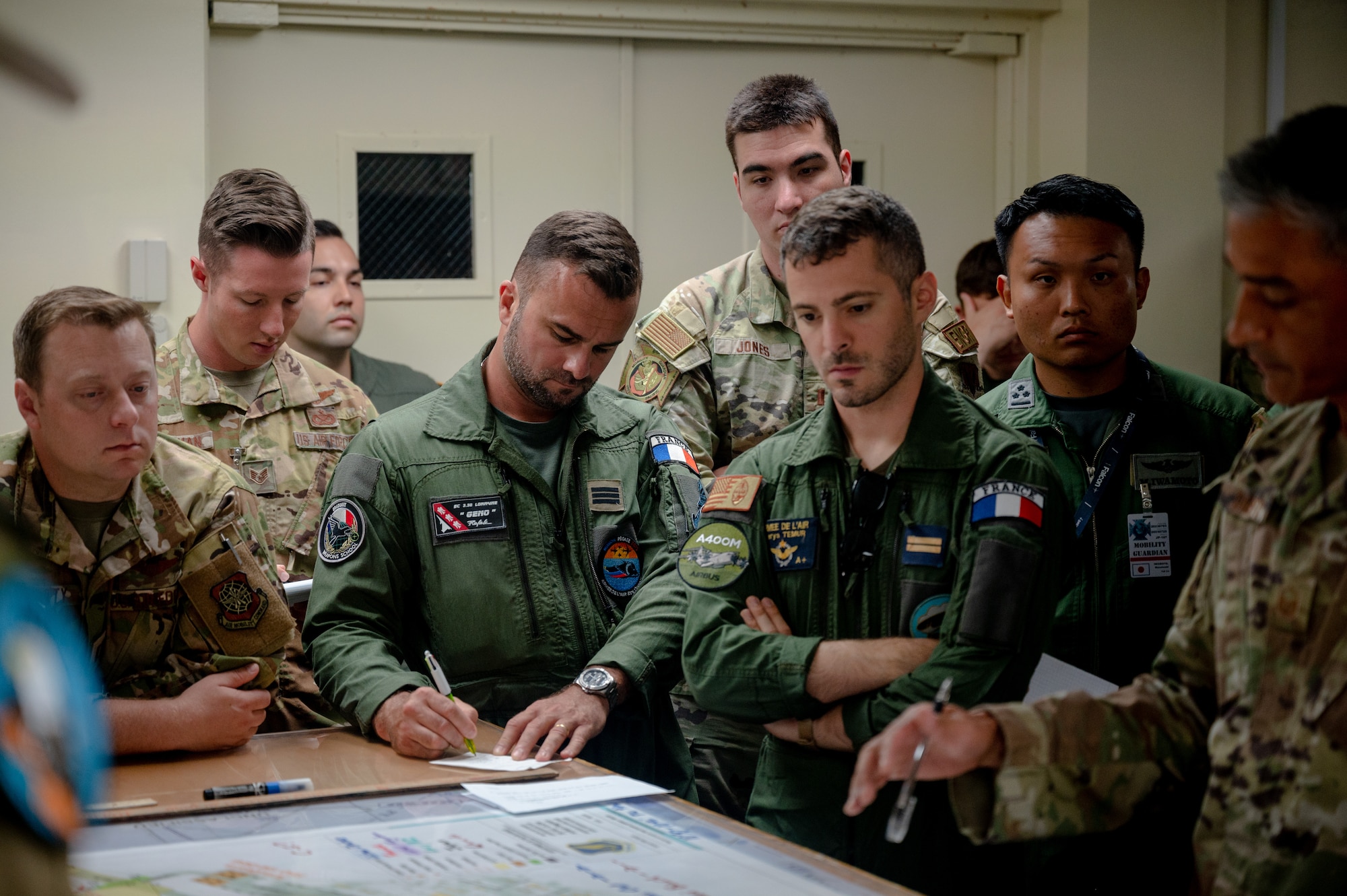 Members from multiple nations air forces gather together to plan an elephant walk during Mobility Guardian 23 in Andersen Air Force Base, Guam, July 18, 2023. MG23 is a multilateral exercise involving joint foreign partners to showcase coalition ability in the INDOPACOM area of responsibility.  (U.S. Air Force photo by Tech. Sgt. Sean Carnes)