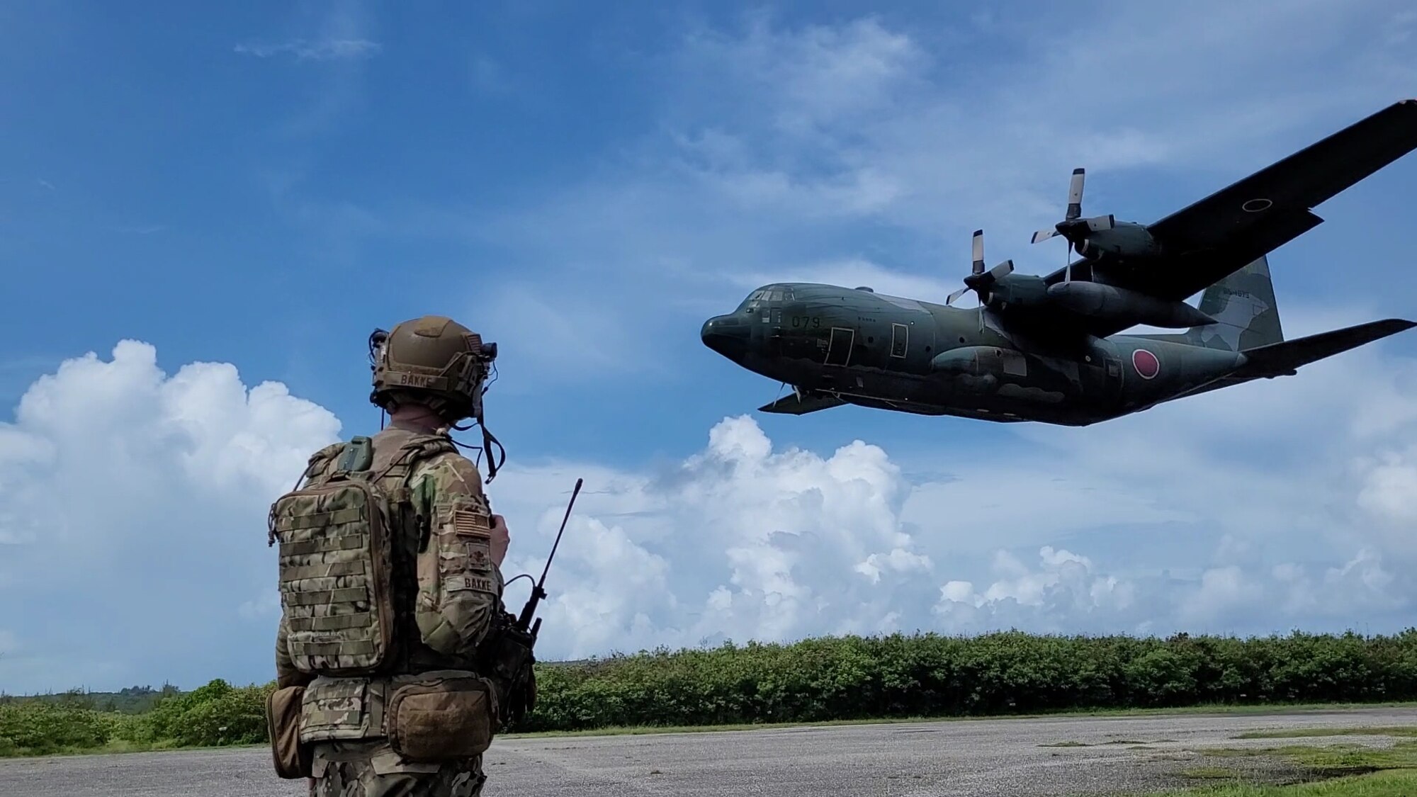 U.S. Air Force Maj. Michael Bakke from the 621st Mobility Support Operations Squadron, Joint Base McGuire-Dix-Lakehurst, New Jersey, prepares as a Japanese C-130 lands on Baker Landing Zone in Tinian, U.S. Commonwealth of the Northern Marianas, July 12, 2023. 621st Mobility Support Operations Squadron members, Air Mobility Liaison Officers, Expeditionary Air Ground Liaison Element members, and Japanese loadmasters participated in Mobility Guardian 23, where their mission was to support the coalition landing zone, drop zone operations, and support cargo preparation. (Courtesy Photo)