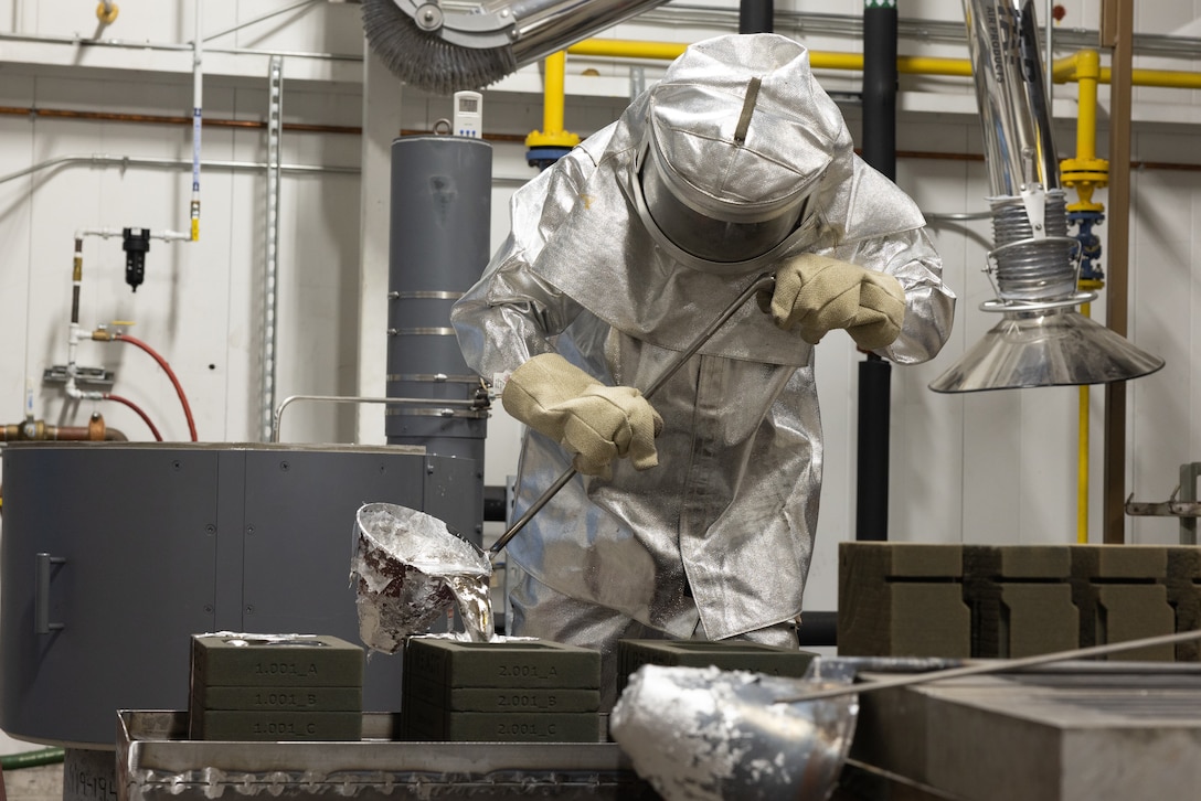 Man wearing fire suit pouring molten aluminum