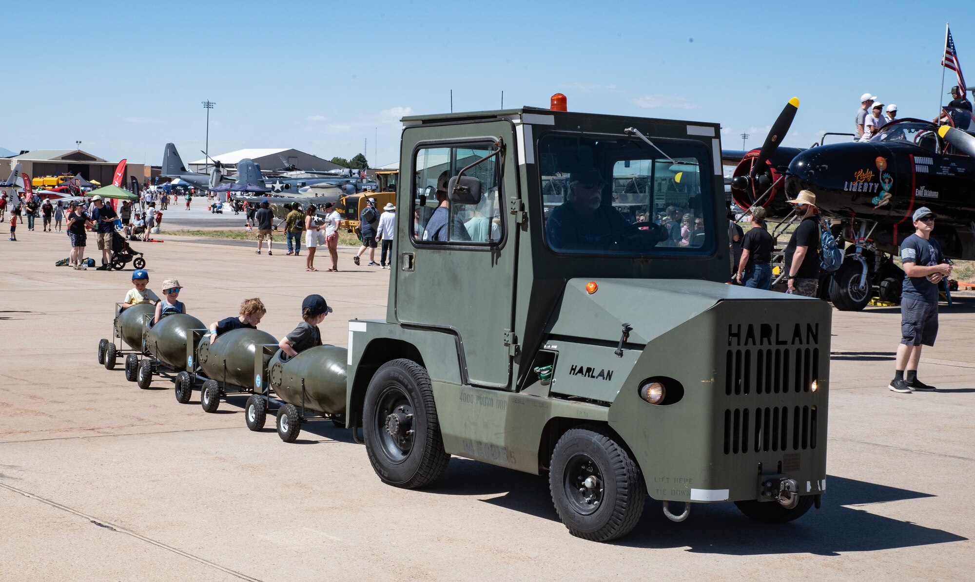 Children being pulled like a train by an Air Force tug.