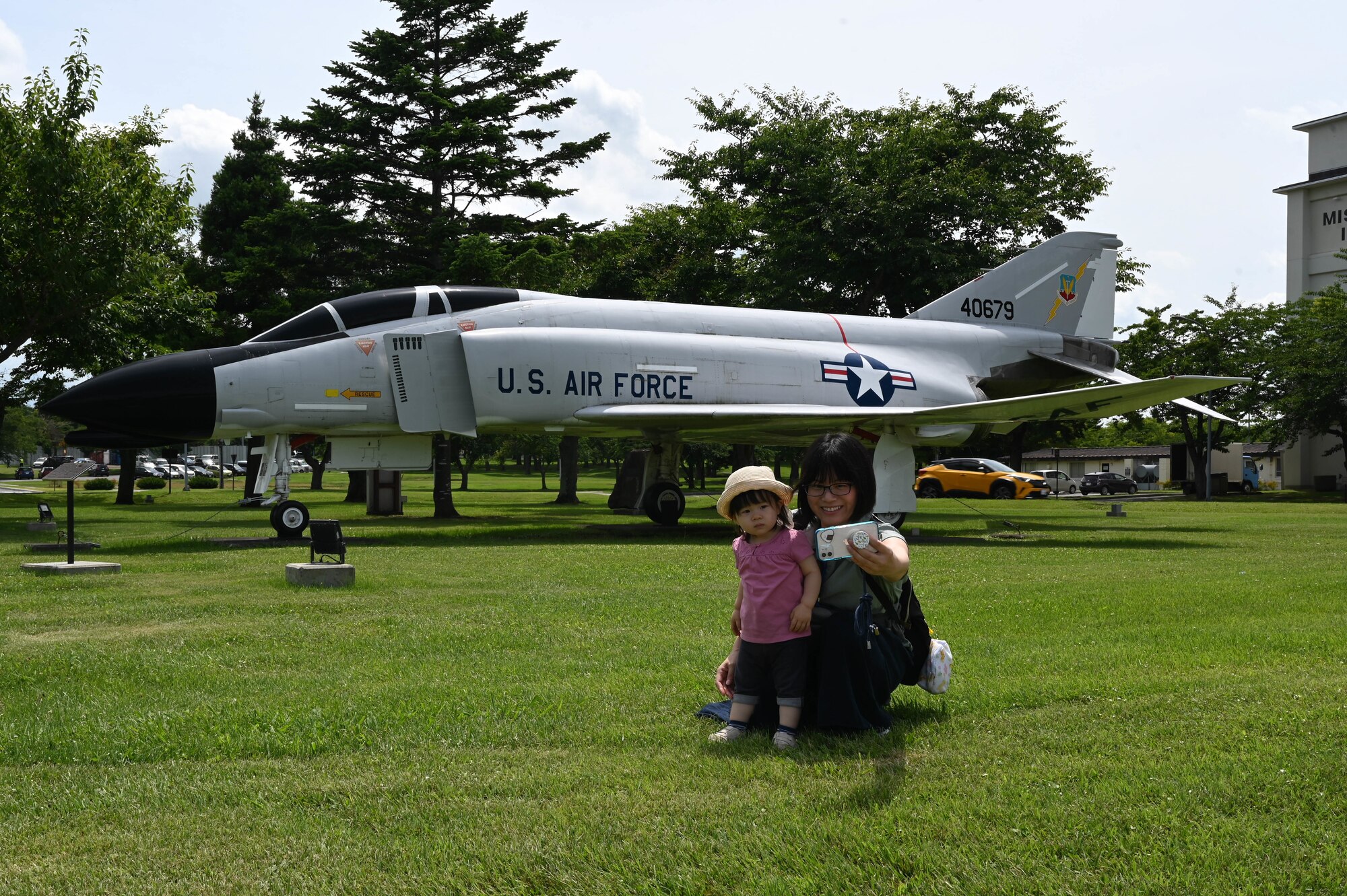Participants of a Misawa Friendship Tour take a photo in front of the F-4C Phantom II static display at Risner circle on Misawa Air Base, Japan, July 14, 2023.