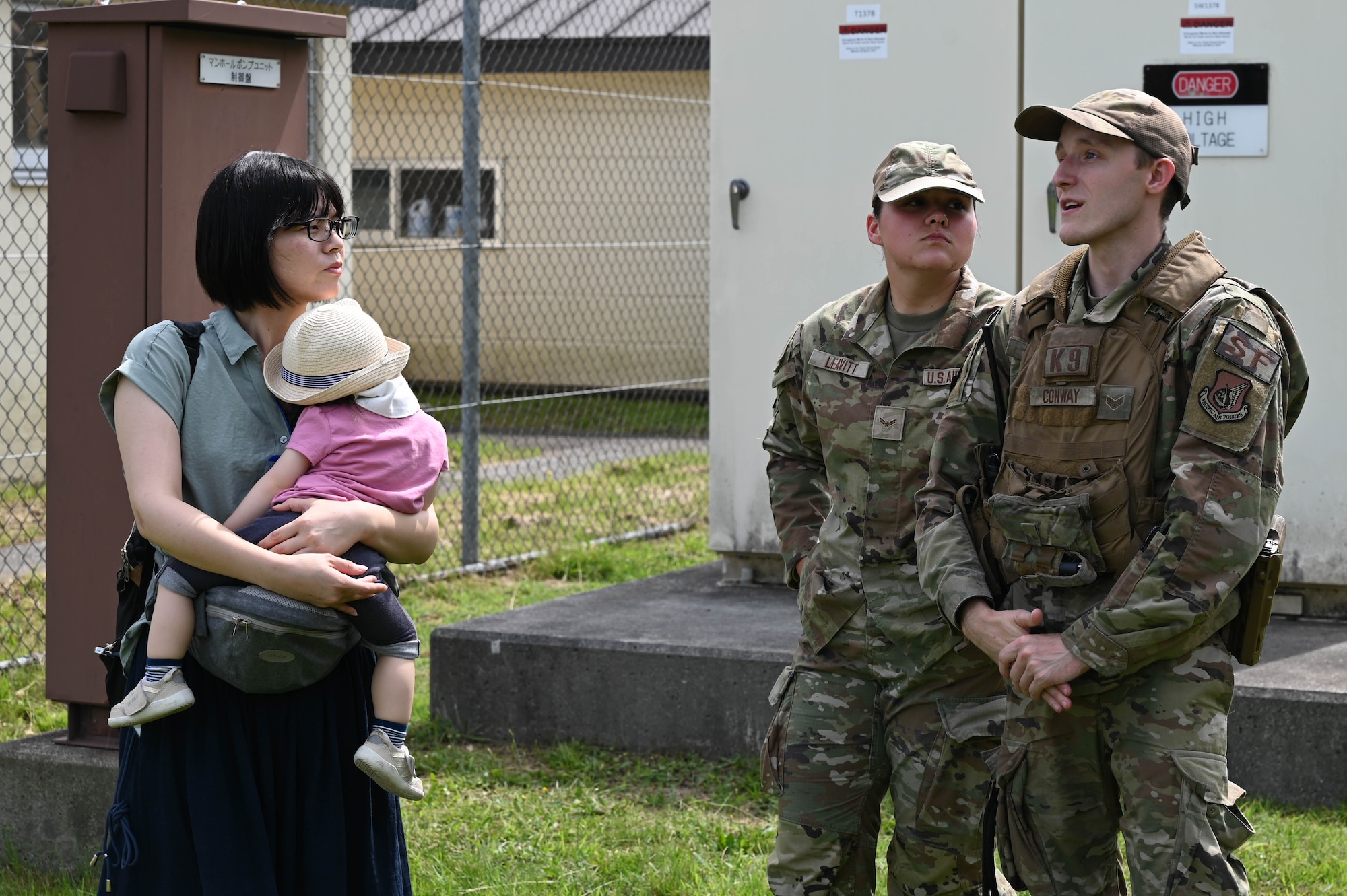 U.S. Air Force Staff Sgt. Bryce Conway, right, 35th Security Forces Squadron military working dog handler, and Airman 1st Class Alexandria Leavitt, center, 35th SFS armorer, talk with a participant of a Misawa Friendship Tour at Misawa Air Base, Japan July 14, 2023.