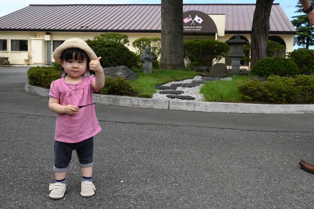 A child participant of a Misawa Friendship Tour gives a thumbs up outside of Lakeview Grille at Misawa Air Base, Japan, July 14, 2023.