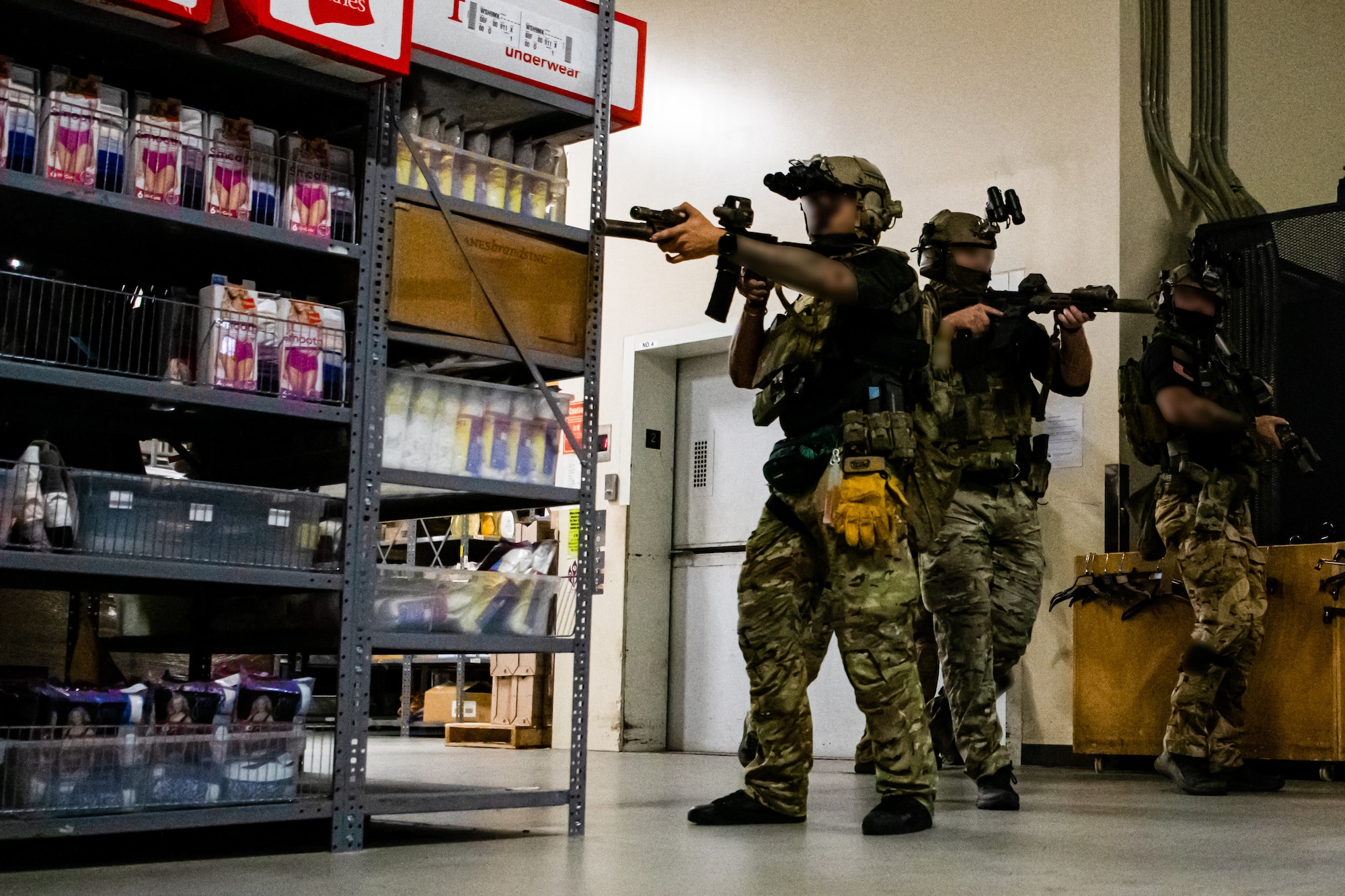 Three U.S. Army Green Berets clear a storage room area.