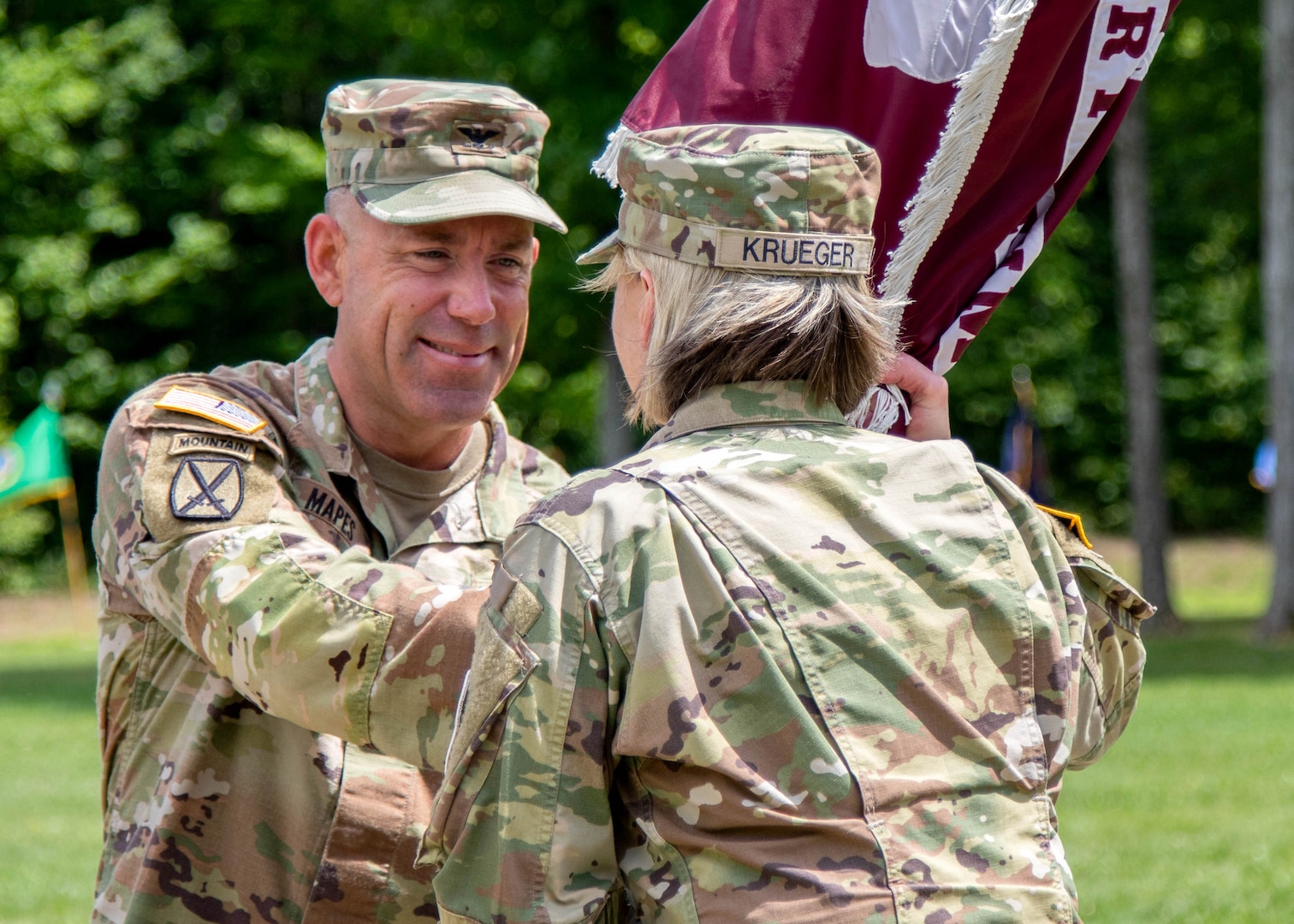 Col. Matthew J. Mapes, the outgoing commander of the U.S. Army Medical Department Activity, Fort Drum, passes the unit’s flag, or colors, to Brig. Gen. Mary V. Krueger, commanding general of Medical Readiness Command, East, during the MEDDAC’s change of command ceremony at Memorial Park, Fort Drum, N.Y., July 21, 2023.