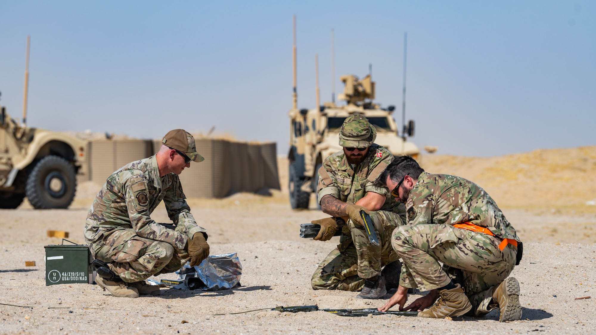 U.S. Air Force explosive ordnance disposal (EOD) technicians assigned to the 386th Expeditionary Civil Engineer Squadron, and a member of the Danish armed forces, place C4 explosives before a controlled detonation near Ali Al Salem Air Base, Kuwait, July 21, 2023. EOD technicians from the 386th ECES frequently work with our coalition partners during demolitions like this to destroy various hazardous materials in a safe and controlled environment. (U.S. Air Force photo by Staff Sgt. Kevin Long)