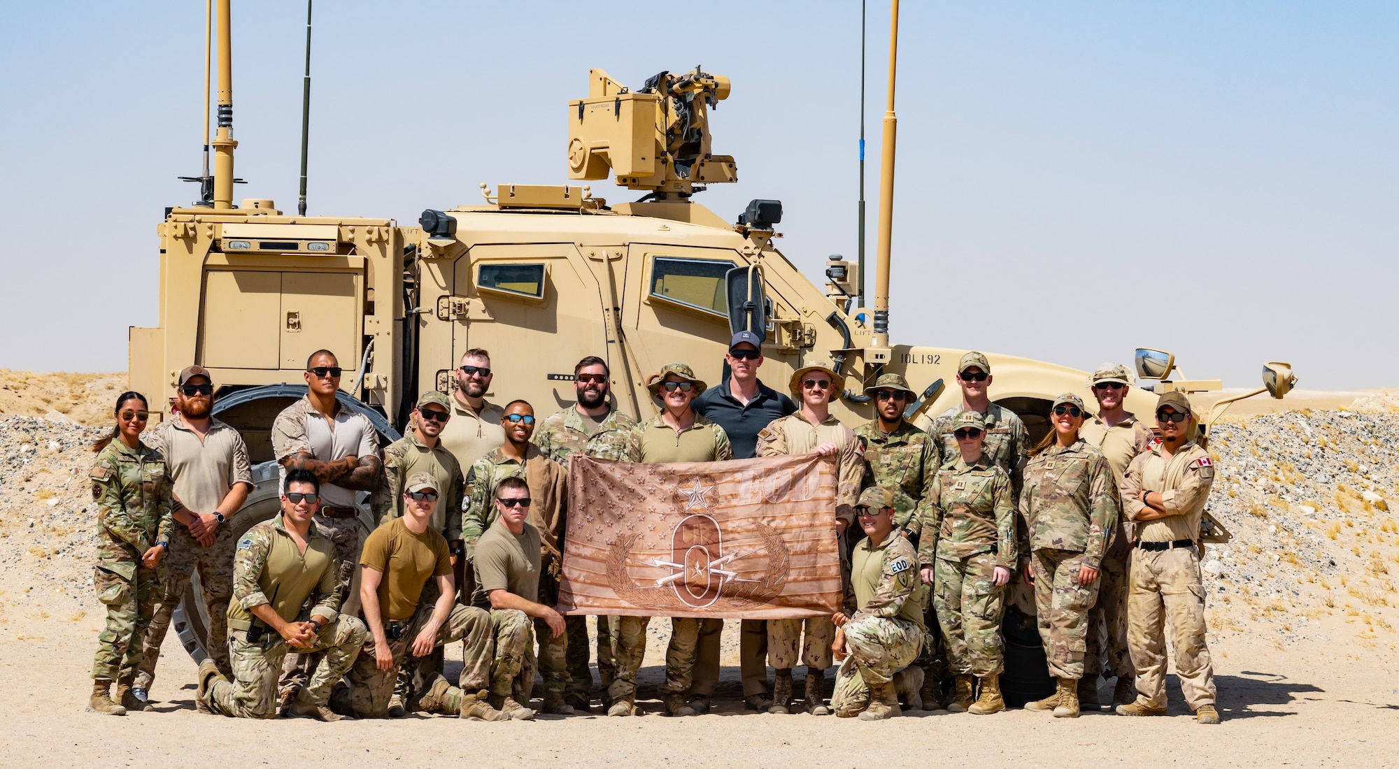 U.S., Canadian, and Danish armed forces members pose for a photo after completing a controlled detonation near Ali Al Salem Air Base, Kuwait, July 21, 2023. Explosive ordnance technicians from the 386th Expeditionary Civil Engineer Squadron frequently work with our coalition partners during demolitions to destroy various hazardous materials in a safe and controlled environment. (U.S. Air Force photo by Staff Sgt. Kevin Long)