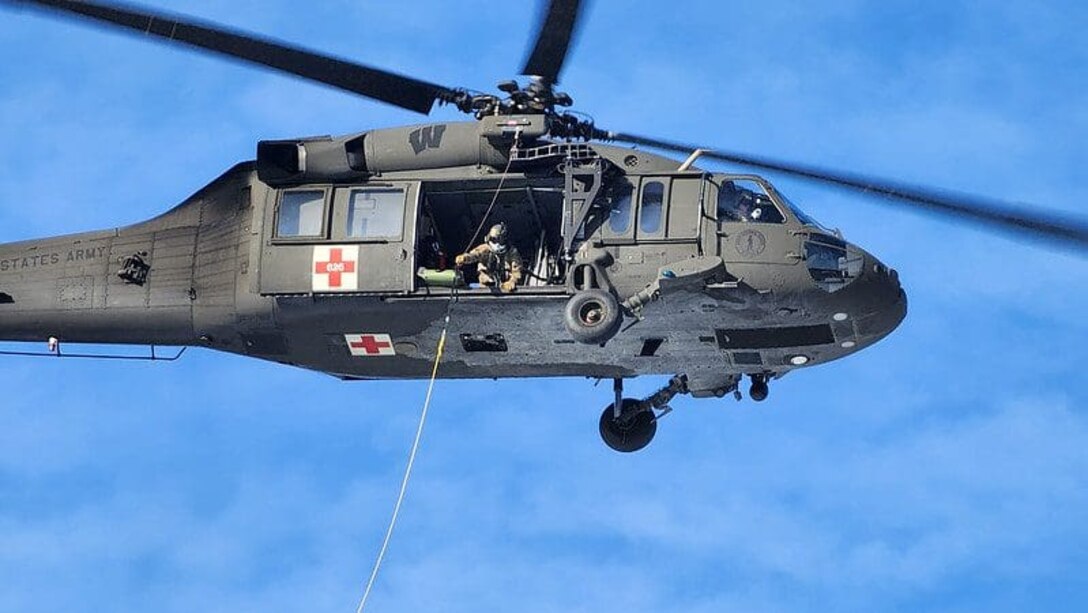 Staff Sgt. Caleb Stenson, a Wisconsin National Guard Balck Hawk crew chief, prepares to hoist a mock casualty in SKED litter during a search and rescue training exercise Jan. 14 in Southern Lincoln County. Photo submitted by National Guard soldier.