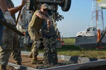 Air Force Staff Sgt. Tyler Cecil, 5th Civil Engineer Squadron pavements and construction equipment craftsman, pours concrete at Minot Air Force Base, North Dakota, July 20, 2023. The 5th Civil Engineer Squadron started construction on a sidewalk for a new airpark. (Air Force photo by Airman 1st Class Alyssa Bankston)