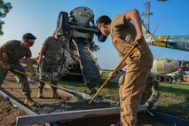 Airmen from the 5th Civil Engineer Squadron spread cement for a new sidewalk at Minot Air Force Base, North Dakota, July 20, 2023. This new path will allow families to be closer to static displays and enjoy Air Force history. (Air Force photo by Airman 1st Class Alyssa Bankston)