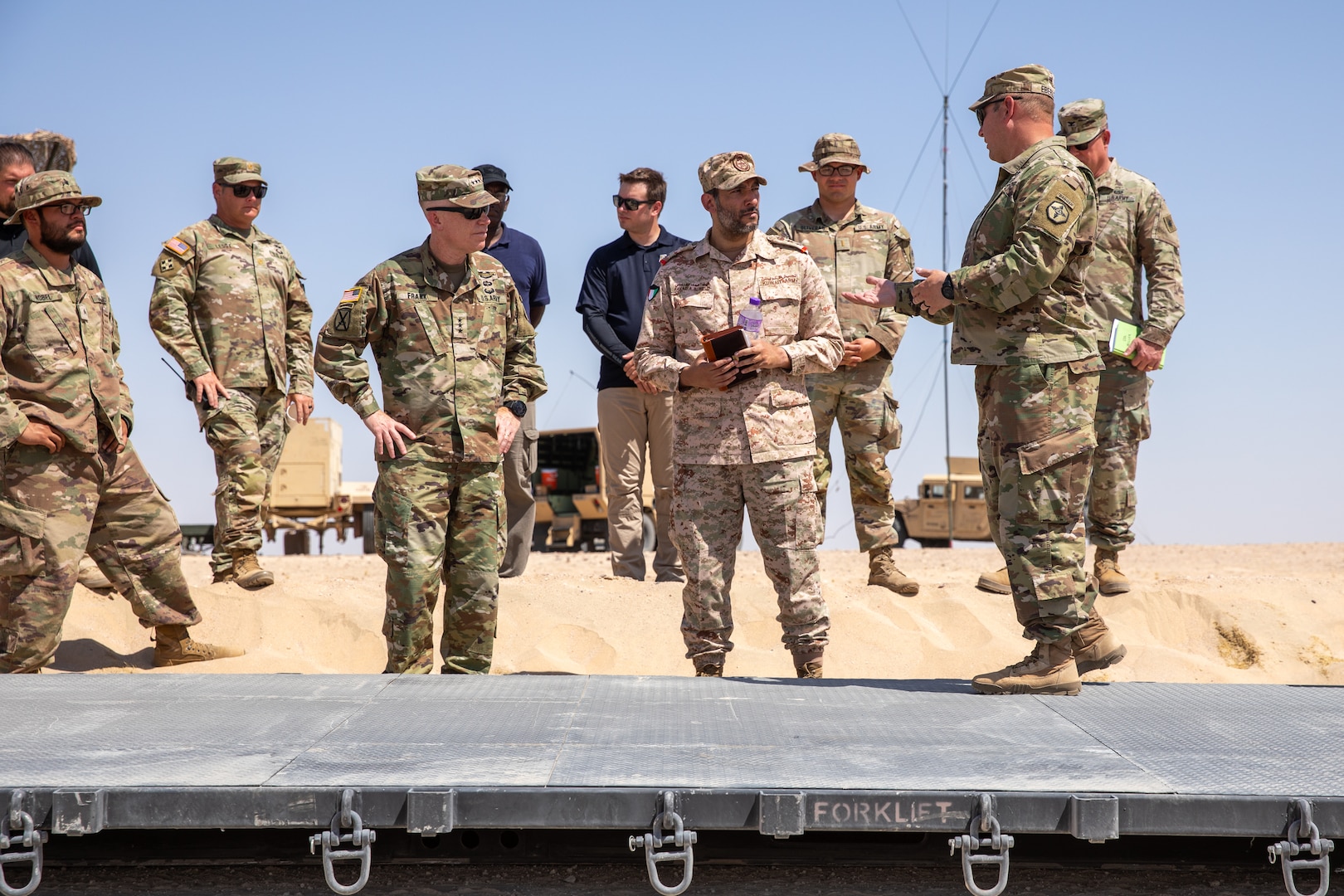 Lt. Gen. Patrick Frank, commanding general of U.S. Army Central, and Col. Fahad A. Buresli with the Kuwait Land Forces receive a capabilities briefing during the USARCENT autonomous vehicle demonstration at the Udari Range Complex near Camp Buerhing, Kuwait, on July 25, 2023. The 371st Sustainment Brigade is currently testing three semi-autonomous palletized load systems, or PLS. The bold measures USARCENT intends to pursue regarding innovation and experimentation will enable USARCENT to campaign creatively, contribute to cross-domain integrated deterrence, and support the effort to build enduring advantages. (U.S. Army Reserve photo by Spc. David Campos-Contreras)