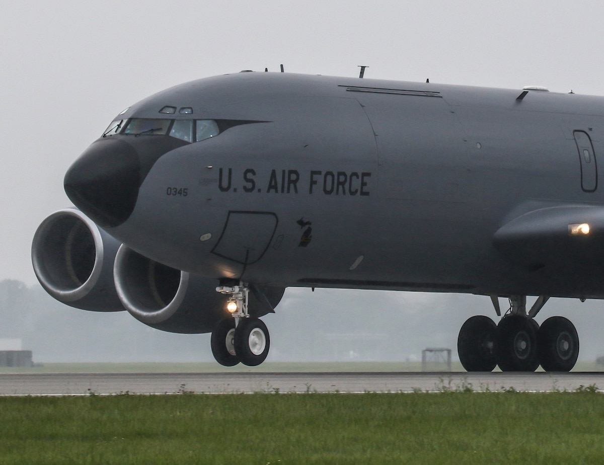 KC-135 aircraft rolling down a runway with front landing gear wheels in the air as it takes off.
