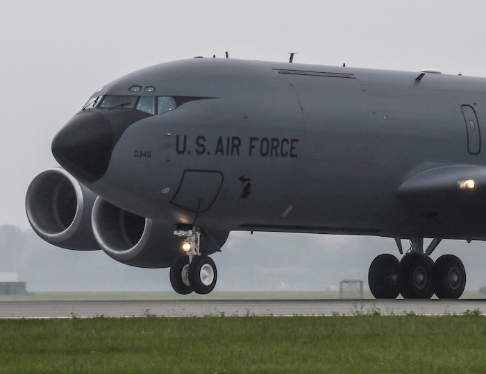 KC-135 aircraft rolling down a runway with front landing gear wheels in the air as it takes off.