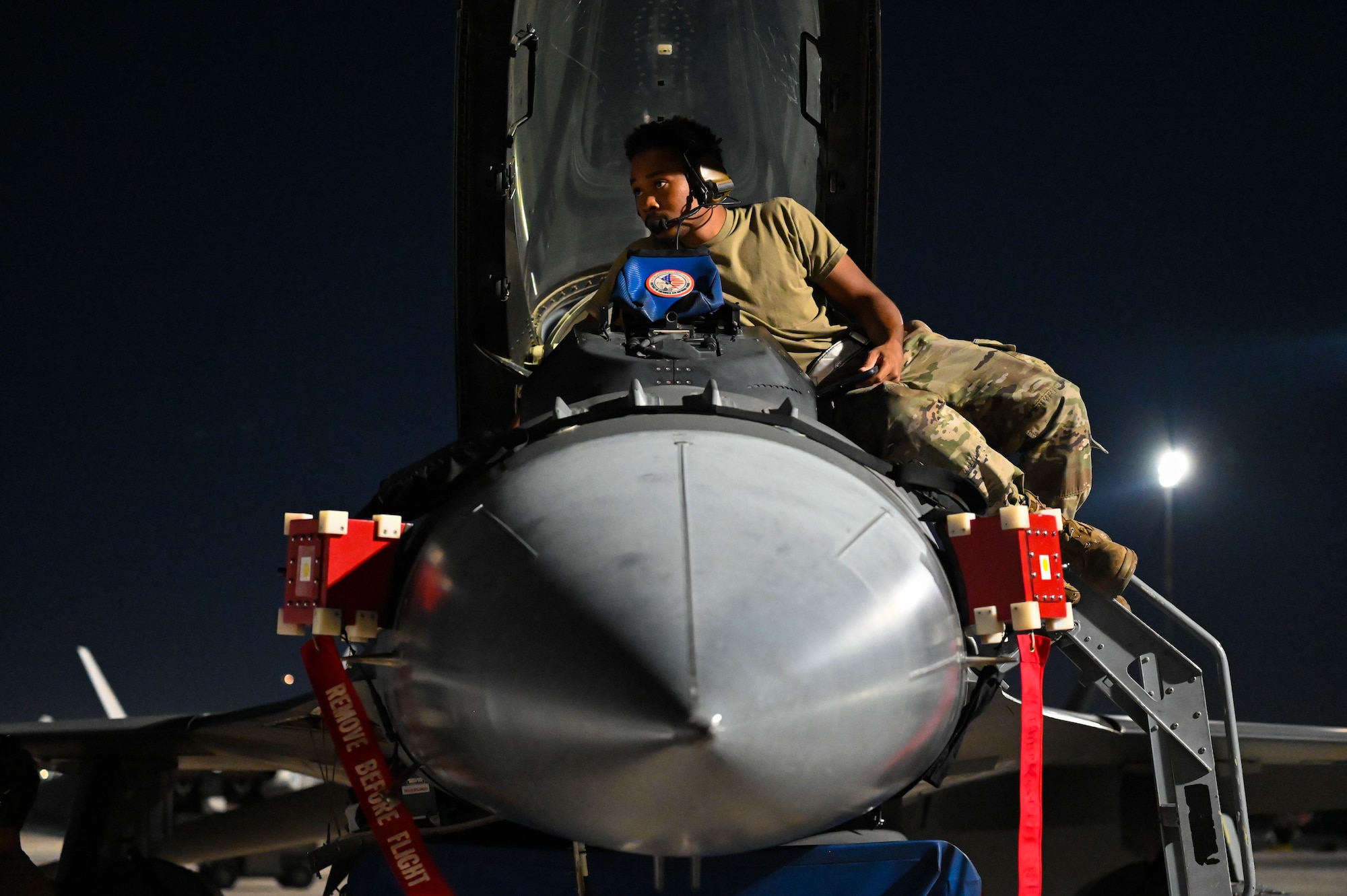 An avionics Airman evaluates the interior of the cockpit of an F-16 Fighting Falcon at Nellis Air Force Base, Nev., July 13, 2023. Effective electronic warfare systems on aircraft are essential for mission success for the warfighters. (U.S. Air Force photo by Capt. Benjamin Aronson)