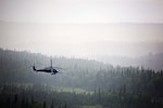 An Alaska Air National Guard HH-60 Pave Hawk helicopter from the 210th Rescue Squadron performs a simulated search and rescue pattern near the Little Susitna River in Alaska. The Pave Hawk conducts day and night personnel recovery operations during war, civil search and rescue, medical evacuation and disaster response operations.