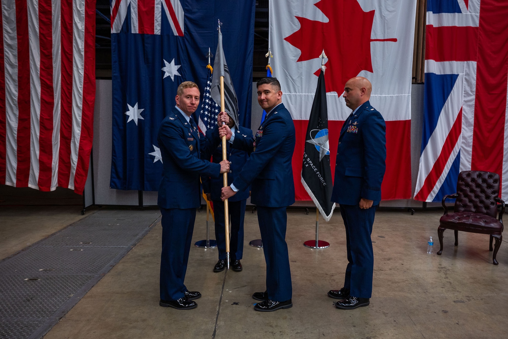 U.S. Space Force Col. Christopher Kennedy, Space Delta 6 commander, left, receives the 65th Cyberspace Squadron (65 CYS) guidon from Lt. Col. Jason Thompson, outgoing 65 CYS commander, middle, while Lt. Col. Jacob Majewski, incoming 65 CYS commander, stands by during the 65 CYS change of command ceremony at Vandenberg Space Force Base, Calif., July 21, 2023. (U.S. Space Force photo by Tech. Sgt. Luke Kitterman)