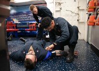 ATLANTIC OCEAN (April 25, 2023) Hospital Corpsman 2nd Class Travis E. Billow, left, observes Gunner’s Mate 3rd Class Luis D. Regalado place a tourniquet on a patient during a Tactical Combat Casualty Care (TCCC) course aboard the Arleigh Burke-class guided-missile destroyer USS Arleigh Burke (DDG 51), April 25, 2023. Arleigh Burke is on a scheduled deployment in the U.S. Naval Forces Europe area of operations, employed by U.S. Sixth Fleet to defend U.S., allied and partner interests. (U.S. Navy photo by Mass Communication Specialist 2nd Class Almagissel Schuring) 230425-N-DE439-1096