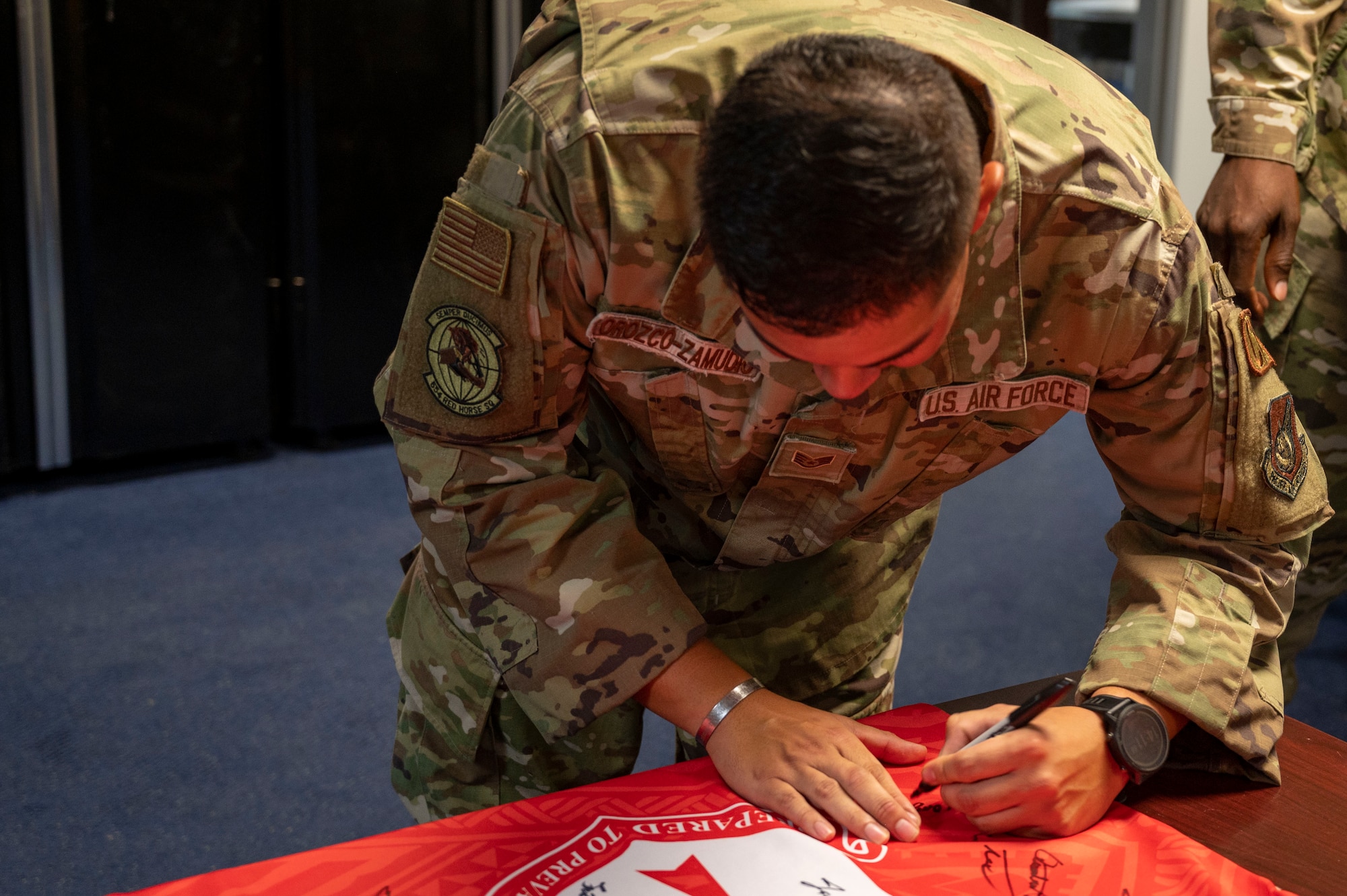 U.S. Air Force Staff Sgt. Abraham Orozco-Zamudio, a heating, ventilation, air conditioning and refrigeration planner assigned to the 554th Rapid Engineer Deployable Heavy Operational Repair Squadron Engineer, signs the Linebacker of the Week jersey at the Pacific Regional Training Center - Andersen, Guam, July 19, 2023. The Team Andersen Linebacker of the Week recognizes outstanding enlisted, officer, civilian and total force personnel who have had an impact on achieving Team Andersen’s mission, vision and priorities. (U.S. Air Force photo by Airman 1st Class Emily Saxton)