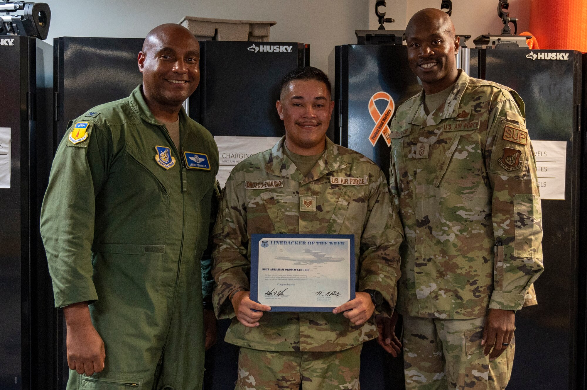 U.S. Air Force Staff Sgt. Abraham Orozco-Zamudio, a heating, ventilation, air conditioning and refrigeration planner assigned to the 554th Rapid Engineer Deployable Heavy Operational Repair Squadron Engineer, receives the Linebacker of the Week Award from U.S. Air Force Col. Larry Fenner, vice commander of the 36th Wing, and U.S. Air Force Chief Master Sgt. Nicholas Taylor, the command chief of the 36th Wing, at the Pacific Regional Training Center - Andersen, Guam, July 19, 2023. The Team Andersen Linebacker of the Week recognizes outstanding enlisted, officer, civilian and total force personnel who have had an impact on achieving Team Andersen’s mission, vision and priorities. (U.S. Air Force photo by Airman 1st Class Emily Saxton)