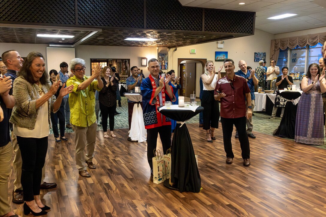 Attendees applaud after watching a live sanshin performance during an awamori tasting at the Habu Pit on Marine Corps Air Station Futenma, Okinawa, Japan, June 10, 2023. Awamori is an alcoholic beverage made from a 600-year-old method of fermenting and distilling a mixture of water, black koji mold, rice, and yeast. The Okinawa Distillers Association provided awamori samples from 10 different distilleries for U.S. Marine leaders of Marine Corps Installations Pacific in future hopes of raising its popularity within the United States. (U.S. Marine Corps photo by Cpl. Thomas Sheng)
