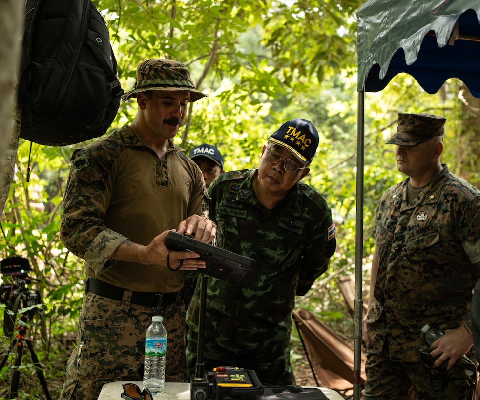U.S. Marine Corps Gunnery Sgt. Jeramie Pawloski, an Explosive Ordnance Disposal (EOD) technician with 3rd EOD Company, 9th Engineer Support Battalion, demonstrates an X-Ray system to General Supathat Narindarabhakdin, Director General of the Thailand Mine Action Center (TMAC), during an EOD level 3 course at Ta Mor Roi training area in Surin Province, Thailand, June 28, 2023. Royal Thai and U.S. Armed Forces train TMAC students in EOD level 3 to advance TMAC’s mission of becoming landmine free. This partnership is aligned with the U.S. Department of Defense’s Humanitarian Mine Action Program, which assists partnered nations affected by landmines, explosive remnants of war, and the hazardous effects of unexploded ordnance. (U.S. Marine Corps photo by Cpl. Moises Rodriguez)