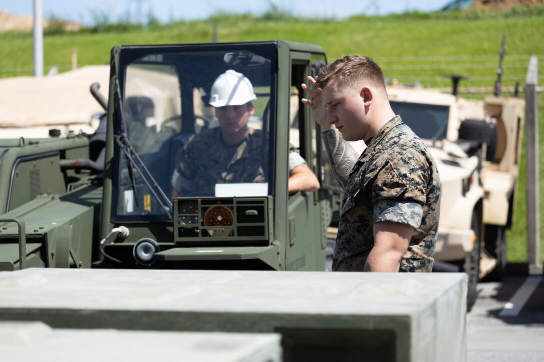 U.S. Marine Corps Lance Cpl. Gabriel Reaid, a mobility non-commissioned officer with 12th Marine Regiment, right, and Lance Cpl. Jayden Ihrke, a heavy equipment operator with 12th Marine Regiment, left, work together to move palletized containers at Camp Hansen, Okinawa, Japan, June 29, 2023. As a part of a strategic mobility exercise (STRATMOBEX), III Marine Expeditionary Force Marine Air-Ground Task Force deployment operations center inspected cargo that will be used in upcoming exercise Resolute Dragon 23. (U.S. Marine Corps photo by Cpl. Alpha Hernandez)