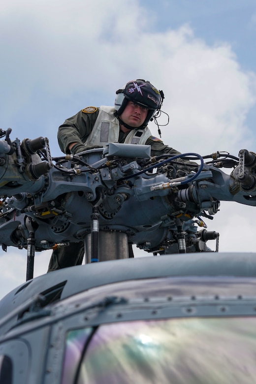 A sailor works on a helicopter.