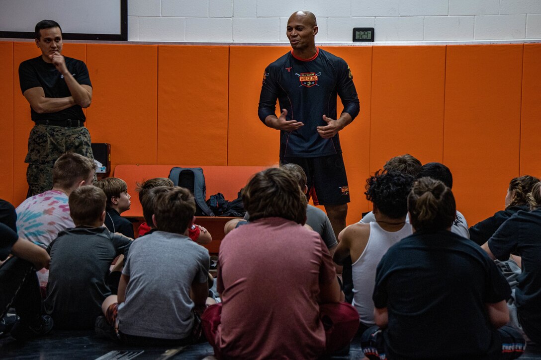 U.S. Marine Corps Capt. Terrence Zaleski, center, the marketing and communications officer with 4th Marine Corps District, Marine Corps Recruiting Command, and SSgt. Richard T. Skripek III, left, a canvassing recruiter with Recruiting Station Lansing, gives an opening brief to set their expectations of the Allegan High School wrestling team at Allegan High School, Allegan, Michigan on January 20, 2023. The clinic provided the opportunity to learn new wrestling techniques and leadership development from a former All-Marine and University of North Carolina at Pembroke wrestler. (U.S. Marine Corps photo by Sgt. Jesse Carter-Powell)