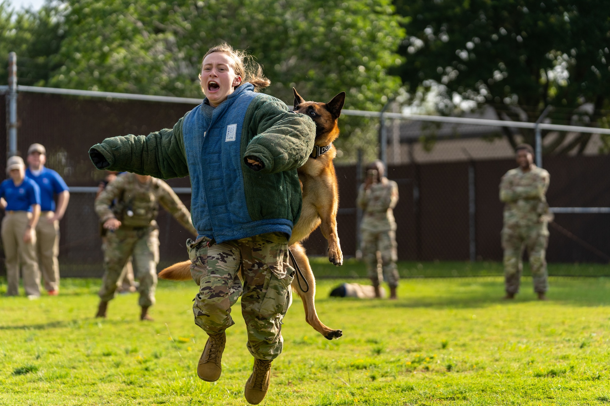 Katie Wofford, U.S. Air Force Academy cadet master sergeant, is taken down by Victor, 81st Security Forces Squadron military working dog, during a demonstration for Pace High School Navy Junior ROTC cadets at Keesler Air Force Base, Mississippi, July 11, 2023.