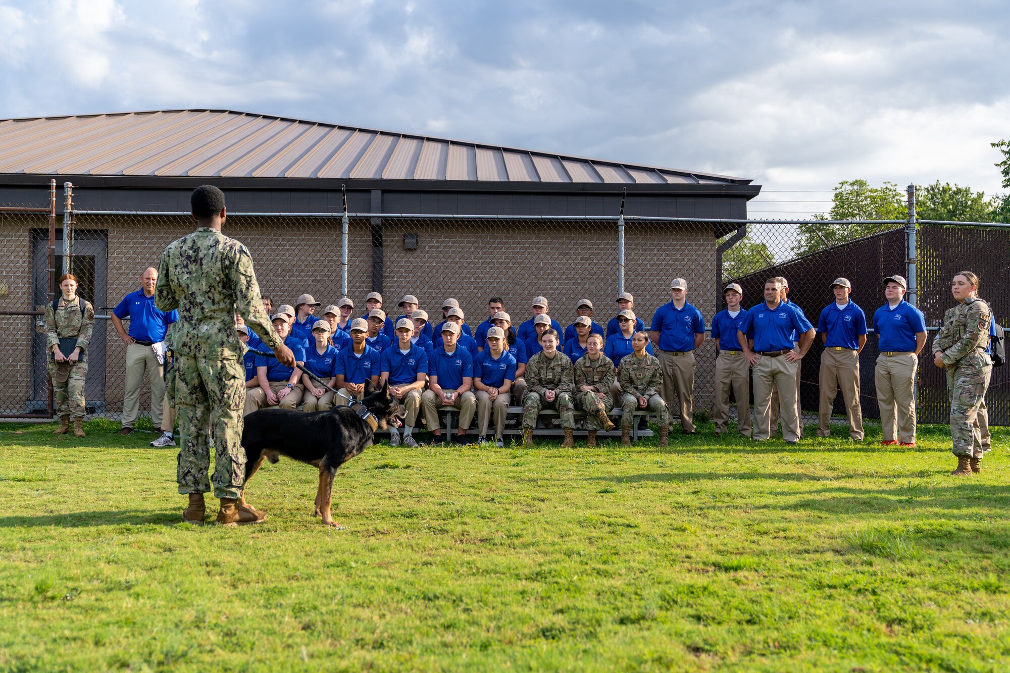 U.S. Navy Seaman Apprentice Christian Green, Naval Construction Battalion Center military working dog handler, and Domper, NCBC MWD, give a demonstration to Pace High School Navy Junior ROTC cadets at Keesler Air Force Base, Mississippi, July 11, 2023.