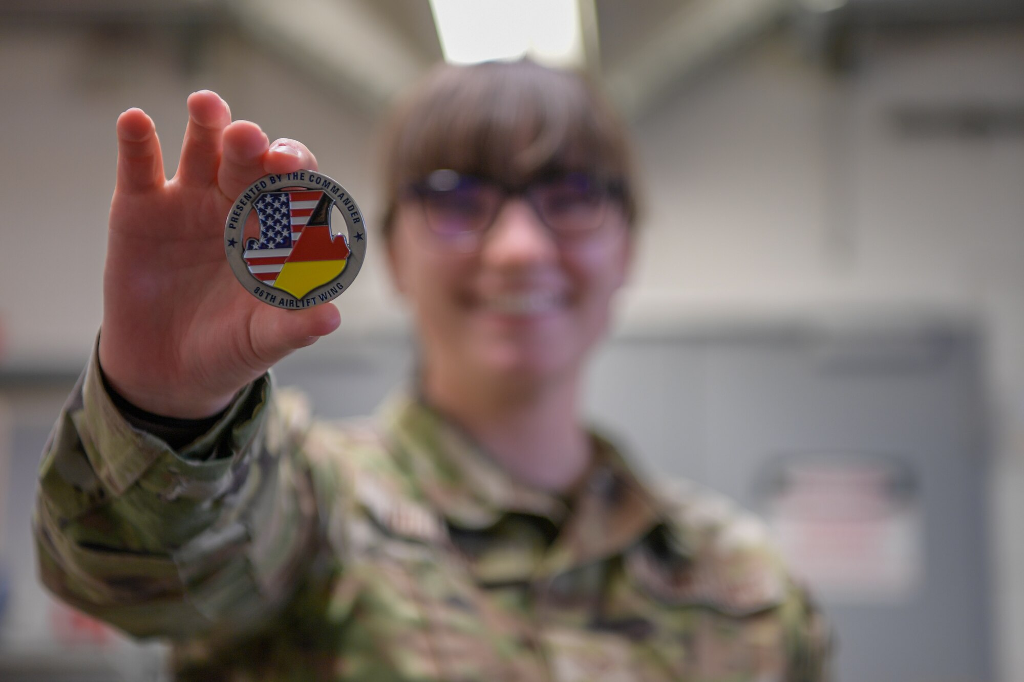U.S. Air Force Senior Airman Carrie Williams holds a coin up for a photo