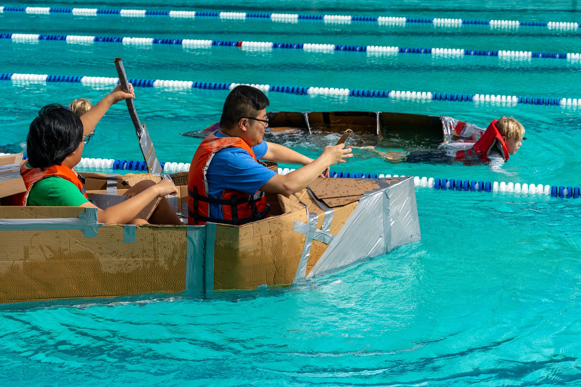 Participants race against each other during the Cardboard Regatta place their boats in the water and get ready to race at Keesler Air Force Base, Mississippi, July 15, 2023.