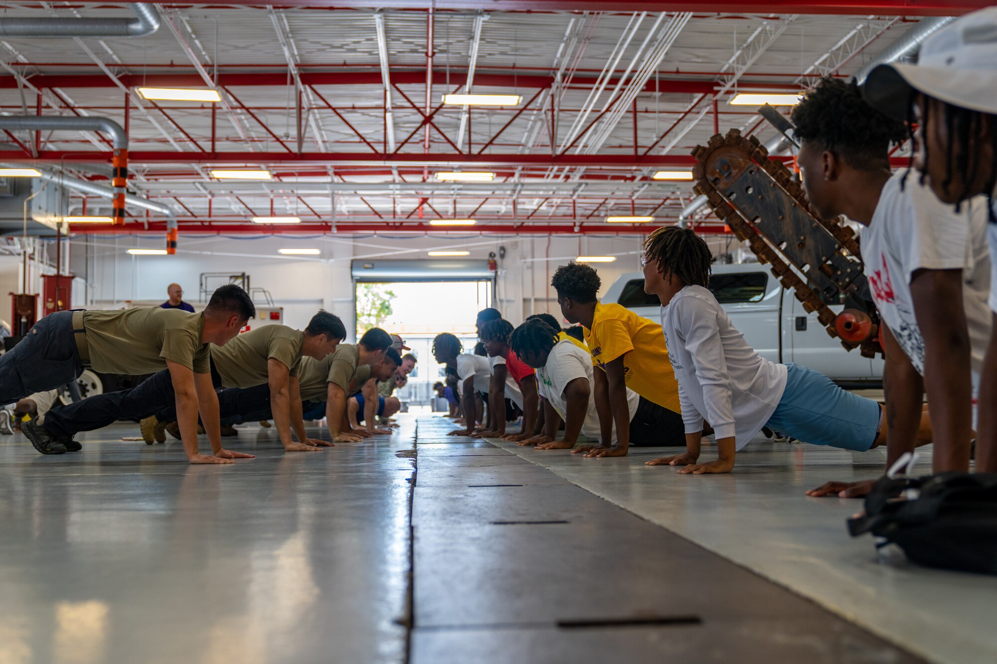 Airmen with the 81st Logistics Readiness Squadron challenge football players from Columbus High School to a push up competition at Keesler Air Force Base, Mississippi, July 17, 2023.