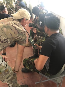 U.S. Air Force Senior Airman Jarret Tyra, a tactical air control party specialist with the 146th Air Support Operations Squadron, Oklahoma Air National Guard, conducts PRC-152 radio training for multinational partners from the Aleutian Islands, Bahamas, Belize and the Dominican Republic during TRADEWINDS23 Exercise at the Guyana Defense Force Jungle Amphibious Training School, Guyana, July 16, 2023. TRADEWINDS is initiated and formulated as part of the Caribbean Basin Initiative, which allows participating nations to forge enduring relationships that will improve security capabilities through the exchange of knowledge and expertise. (U.S. Air National Guard photo courtesy of 1st Lt. Christopher Vaughan)