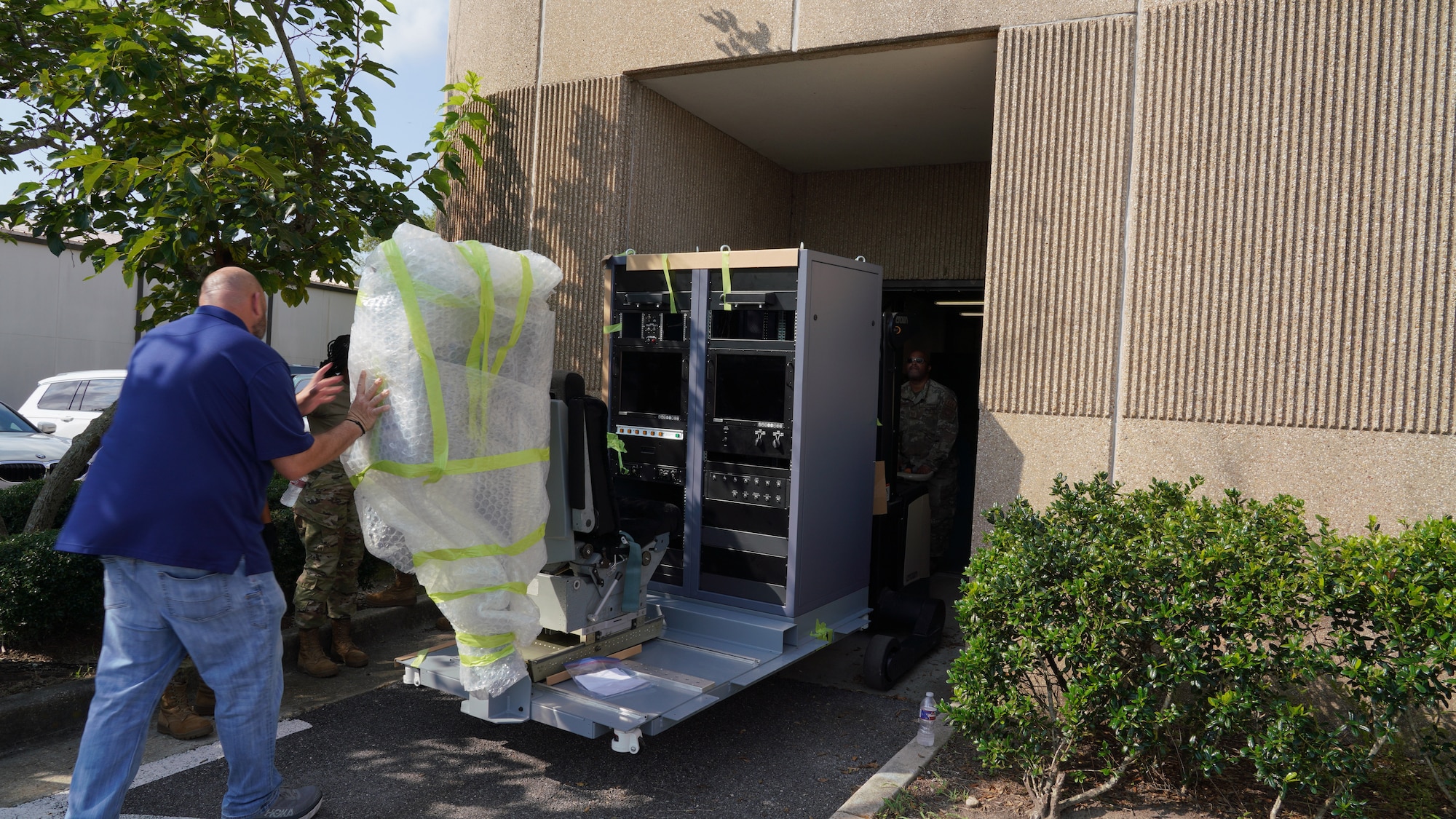 Male civilian from 502nd Trainer Development Flight helps move the new weather officer static trainer into the building.