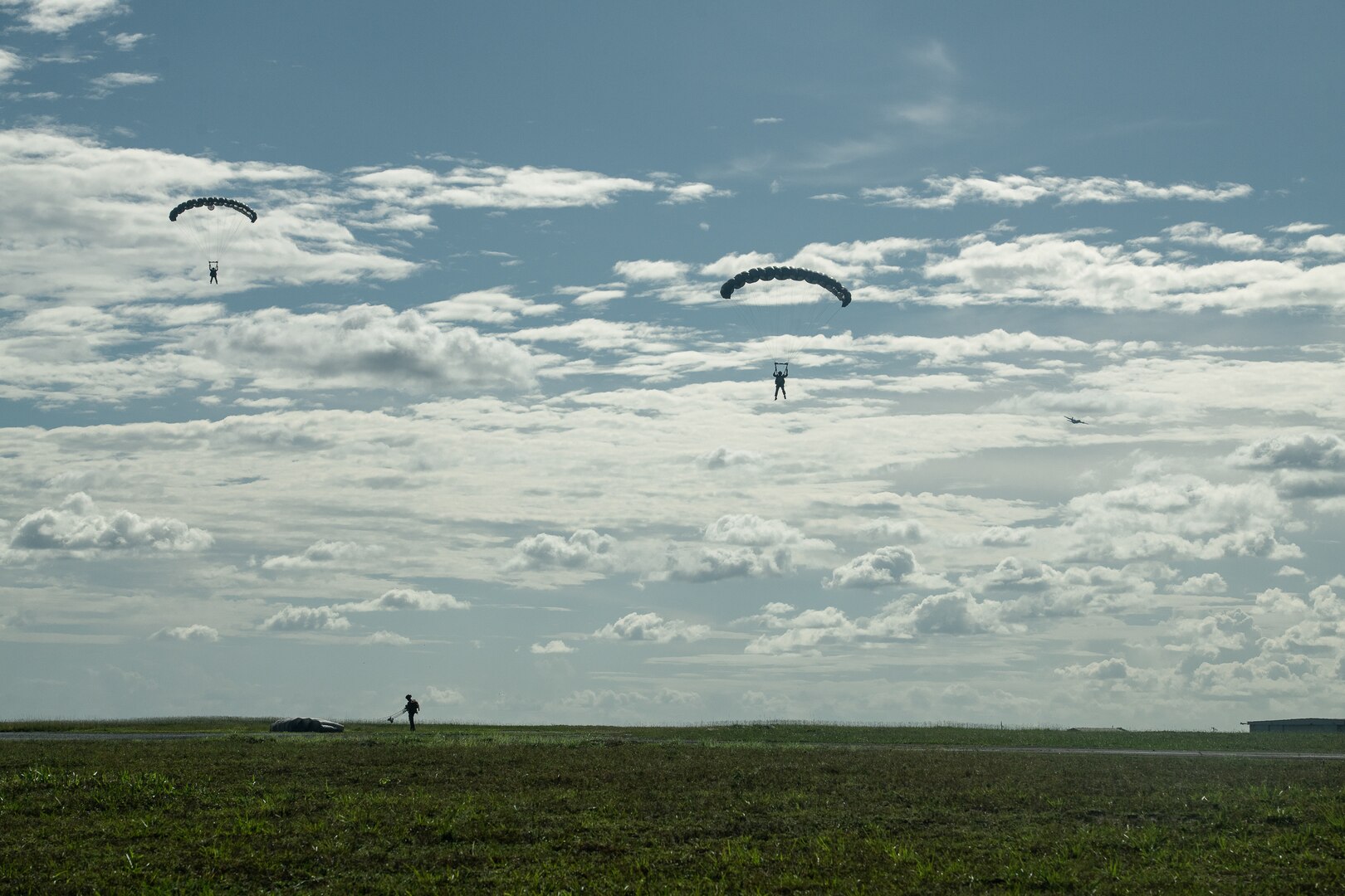 photo: U.S. Army soldiers parachute into Air Base London, Guyana, from the 403d Wing C-130J Super Hercules aircraft flying behind them during TRADEWINDS23 Exercise July 18, 2023. The different training components of the exercise are focused on increasing regional cooperation throughout the Caribbean and Caribbean Basin. (U.S. Air National Guard photo by Tech. Sgt. Brigette Waltermire)