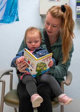 Nicole Hales reads to her daughter Emerson Hales after receiving a book for the Reach Out and Read Initiative during a clinical visit at the pediatrics clinic June 19, 2023, at Beale Air Force Base, California.
