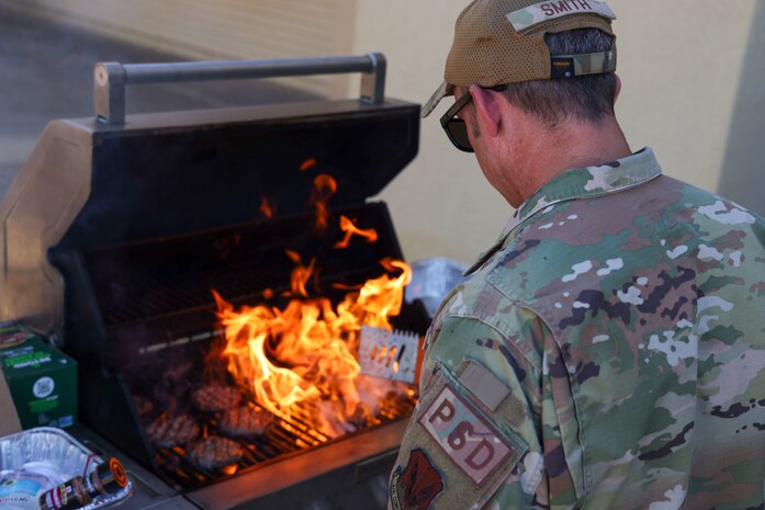 U.S. Air Force Senior Master Sgt. Allen Smith, 9th Physiological Support Squadron superintendent for U-2 operations, flips burgers on a grill July 25, 2023, at Beale Air Force Base, California.