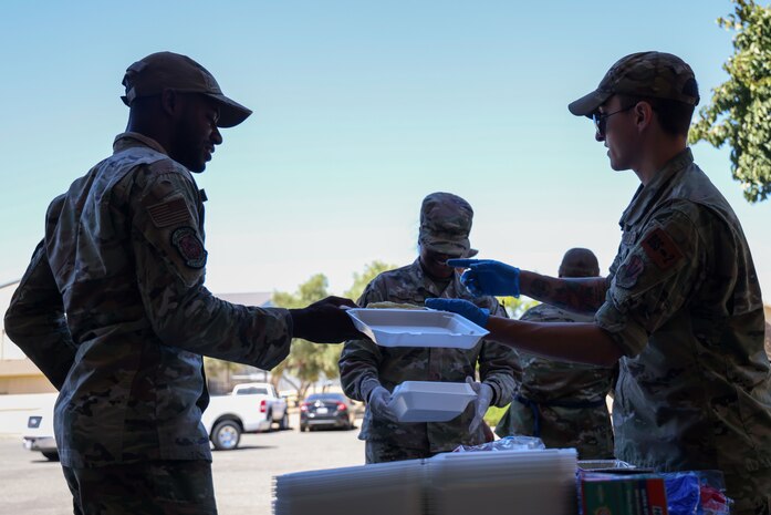 U.S. Air Force Staff Sgt. Hunter Layton, 553rd Intelligence Squadron intelligence analyst, gives a meal to a Beale Airman July 25, 2023, at Beale Air Force Base, California.