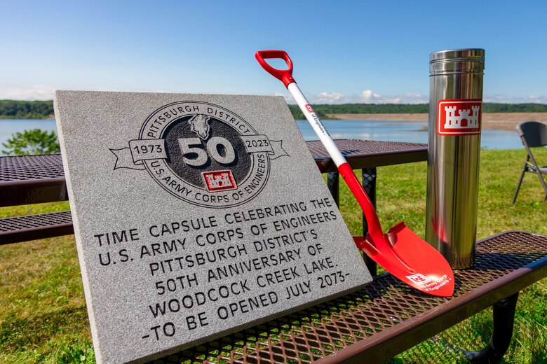 A stone tablet was placed overtop the time capsule after it was buried at Woodcock Creek Lake in Saegertown, Pennsylvania, July 14, 2023. Community leaders and Corps of Engineers employees gathered on a summer morning to celebrate Woodcock Creek Dam’s 50th anniversary. The corps built Woodcock Creek Dam to reduce floods along the French Creek, saving communities such as Saegertown and Meadville from catastrophic flooding year after year and has prevented more than $38 million in flood damages since its construction in 1973. The time capsule will be opened at the dam’s 100th celebration in 2073. (U.S. Army Corps of Engineers Pittsburgh District photo by Andrew Byrne)