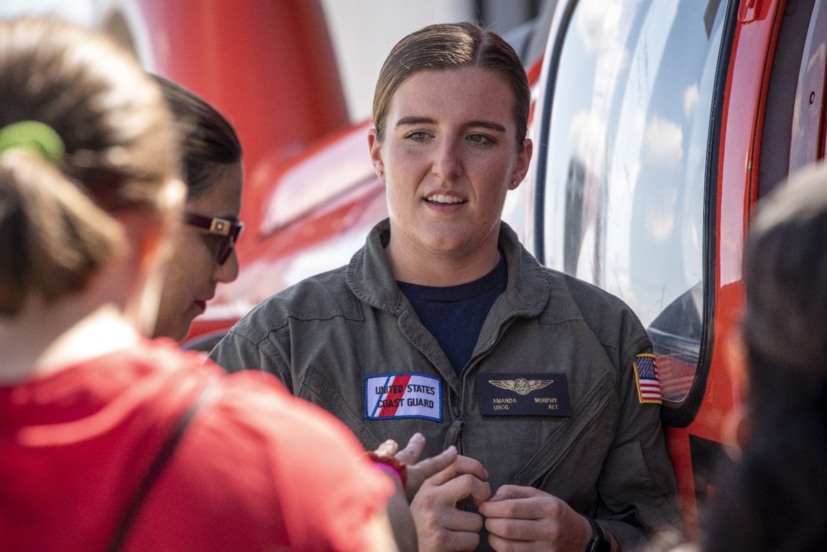 Coast Guard Petty Officer 3rd Class Amanda Murphy, an avionics electrical technician at Coast Guard Air Station Houston, interacts with community members at a Girls in Aviation event at the Lone Star Flight Museum in Houston, Texas, Sept. 23, 2022. Air Station Houston personnel provided a static helicopter display and talked with girls about aviation career opportunities in the Coast Guard. (U.S. Coast Guard photo by Petty Officer 1st Class Corinne Zilnicki)